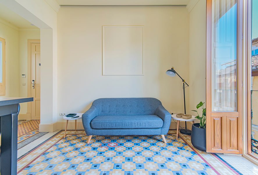 Apartamento Basic King 4 Sofá de diseño de color azul sobre suelo original de mosaiko