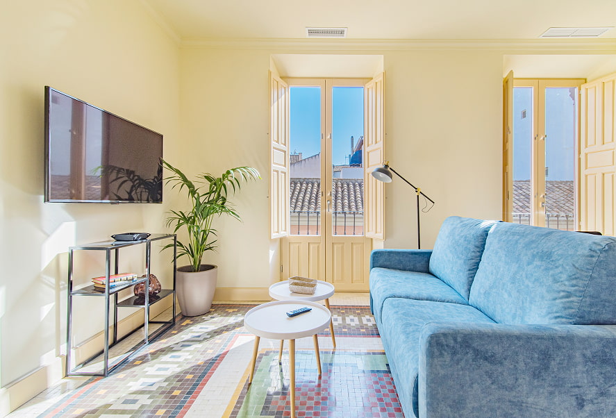 Apartamento Standard 1 Zona de estar, con sofá azul, muebles de diseño y TV de pantalla plana