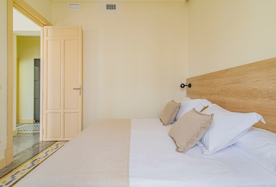 Apartamento Superior King 3 Vista lateral de la habitación con cama King Size y cabecero de madera